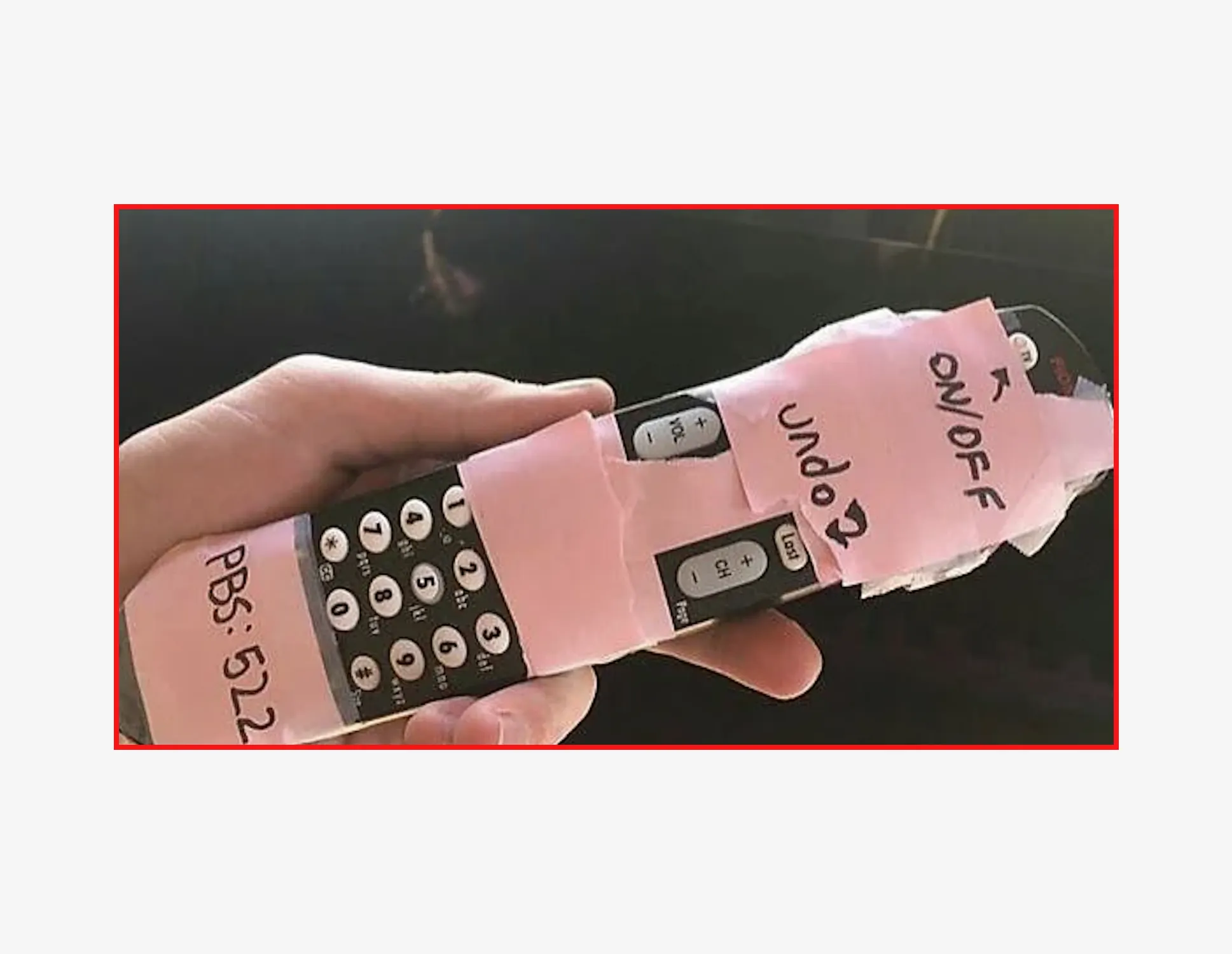 A TV remote wrapped in pink tape with hand-written labels: ON/OFF, UNDO, PBS: 522